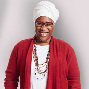 Headshot of person looking at camera wearing glasses and headwrap