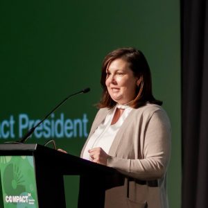 Bobbie Laur standing at a podium on a stage